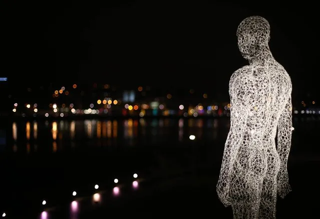 A figure from the series called The Travellers by Cedric Le Borgne over looking the peace bridge in Londonderry as the Lumiere festival opens as part of the UK City of Culture celebrations, Londonderry, on November 28, 2013. (Photo by Niall Carson/PA Wire)
