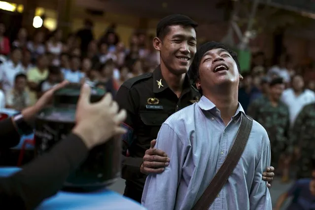 A young man reacts after pulling a ticket out from a plastic bucket during an army draft held at a school in Klong Toey, the dockside slum area in Bangkok April 5, 2015. (Photo by Athit Perawongmetha/Reuters)