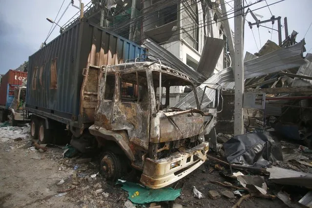 A charred truck sits in the wreckage after and explosion and raging fire at a chemical factory in Samut Prakan province, Thailand, Monday, July 5, 2021. A massive explosion at a factory on the outskirts of Bangkok has damaged homes in the surrounding neighborhoods and prompted the evacuation of a wide area over fears of poisonous fumes from burning chemicals and the possibility of additional denotations. At least one person has been killed and dozens have been injured. (Photo by AP Photo/Stringer)