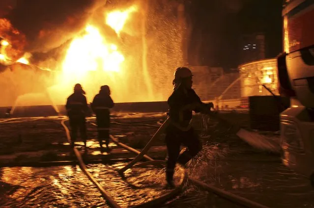 Firefighters try to extinguish a fire at a petrochemical plant in Zhangzhou, Fujian province April 7, 2015. At least six people were injured after an explosion hit part of an oil storage facility on Monday at Dragon Aromatics, Xinhua reported. The fire, which had been put off, resumed at around 7:40 p.m. on Tuesday. (Photo by Reuters/Stringer)