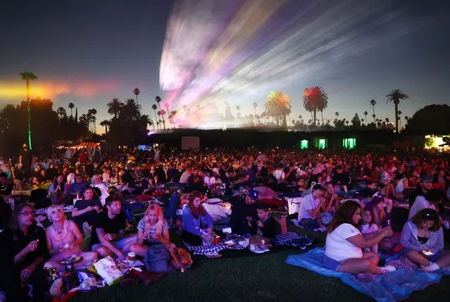 People sit before the start of Cinespia’s screening of “The Wizard of Oz” at Hollywood Forever Cemetery, presented by Amazon Studios & Prime Video, on July 31, 2021 in Los Angeles, California. Summer screenings have returned to the iconic cemetery after a hiatus amid the pandemic last summer. Actress Judy Garland is laid to rest at the cemetery where many movie legends are buried. (Photo by Mario Tama/Getty Images)