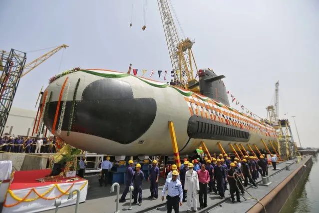 Employees stand around the Indian Navy's first Scorpene submarine before being undocked from Mazagon Docks Ltd, a naval vessel ship building yard, in Mumbai April 6, 2015. Irked by India's status as the world's biggest arms importer, Prime Minister Narendra Modi wants to build an advanced defence industry but almost a year into his “Make in India”. (Photo by Shailesh Andrade/Reuters)