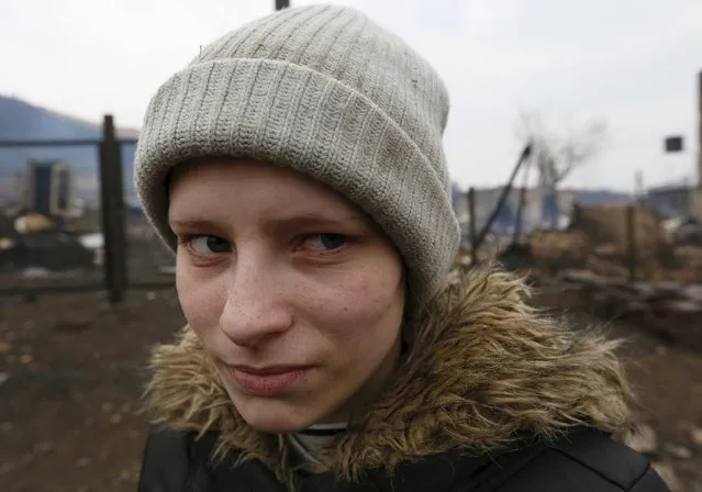 Local resident Rita Chernyshova stands amidst the debris of her burnt house in the settlement of Shyra, damaged by recent wildfires, in Khakassia region, April 13, 2015. (Photo by Ilya Naymushin/Reuters)
