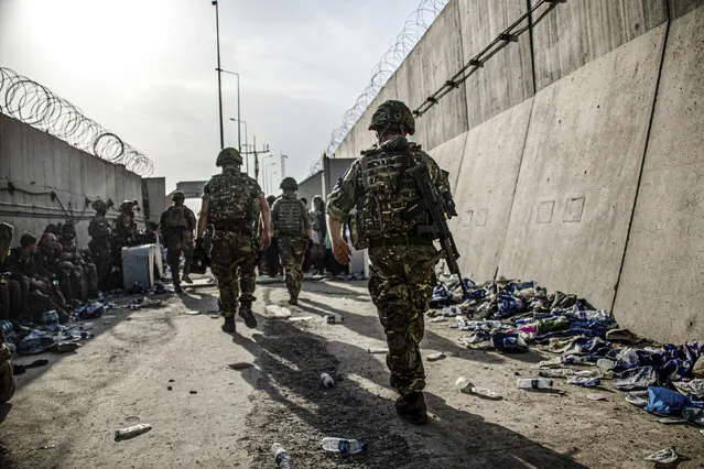 In this photo issued by Britain's Ministry of Defence (MoD), showing members of UK Armed Forces who are working to evacuate entitled personnel from Afghanistan's Kabul airport, Monday August 23, 2021.  Defence Secretary Ben Wallace has said the Kabul evacuation effort is “down to hours now, not weeks” as he conceded Britain's involvement will end when the US leaves Afghanistan. (Photo by LPhot Ben Shread/MoD via AP Photo)
