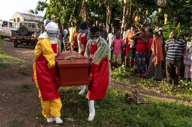 Ugandan Red Cross workers carry a coffin containing an Ebola victim during a Safe and Dignified Burial on October 11, 2022 in Mubende, Uganda. Emergency response teams, isolation centres and treatment tents have been set up by the Ugandan health authorities around the central Mubende district after 17 recorded deaths and 48 confirmed cases from an outbreak of the Ebola virus. The first death from this outbreak of the Ebola-Sudan strain of the virus was announced on 19 September and as yet, there is no vaccine for this strain. (Photo by Luke Dray/Getty Images)
