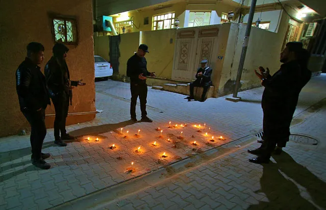 In this photo taken on Tuesday, February 5, 2019, friends and relatives of Alaa Mashzoub pray at his assassination site in Karbala, Iraq. Alaa Mashzoub, the Iraqi novelist who was gunned down this week in Karbala, was a secular civil society activist who used his bike to get around the Shiite holy city's infamous traffic and road closures. He was also an outspoken critic of foreign interferences in Iraqi affairs Iraq and political meddling by powerful militias backed by Iran. On Saturday, he was gunned down by unknown assailants who silenced him with 13 bullets as he rode his bicycle home for the last time. (Photo by Anmar Khalil/AP Photo)
