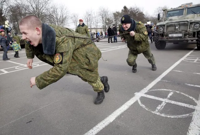 Belarussian soldiers from the Interior Ministry special unit drag a car during holiday celebrations at the outskirts of Minsk, Belarus, February 28, 2016. The holiday called Maslenitsa celebrates the end of winter and is the only purely Slavic holiday, dating back to pagan times. (Photo by Tatyana Zenkovich/EPA)