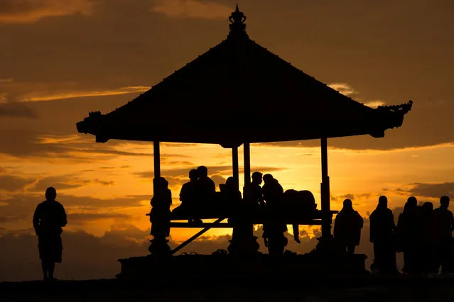 People enjoy the sunrise at Sanur Beach in Denpasar, Bali Island, Indonesia January 1, 2017. (Photo by Agung Parameswara/Reuters)