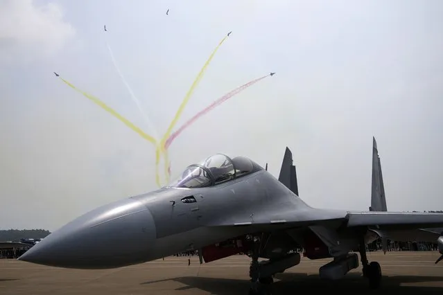 Members of the “August 1st” Aerobatic Team of the Chinese People's Liberation Army (PLA) Air Force perform near a J-16D electronic warfare airplane during the 13th China International Aviation and Aerospace Exhibition, also known as Airshow China 2021, on Wednesday, September 29, 2021, in Zhuhai in southern China's Guangdong province. (Photo by Ng Han Guan/AP Photo)