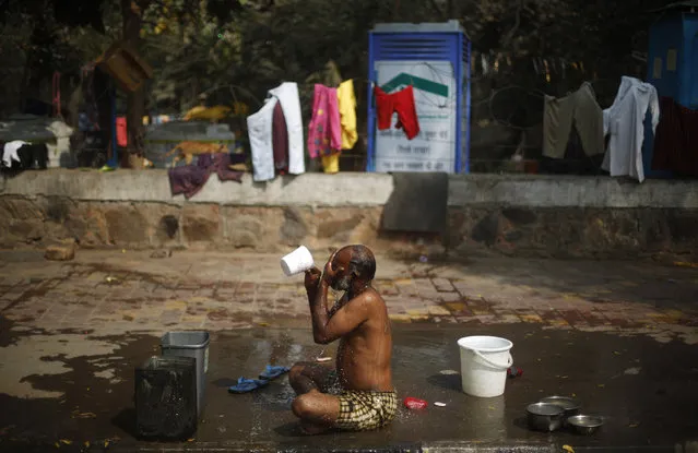 A man bathes by the roadside in a slum area in New Delhi, India, March 2, 2016. (Photo by Adnan Abidi/Reuters)