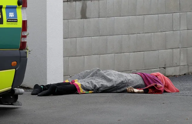 A body lies on the footpath outside a mosque in central Christchurch, New Zealand, Friday, March 15, 2019. A witness says many people have been killed in a mass shooting at a mosque in the New Zealand city of Christchurch. (Photo by Mark Baker/AP Photo)