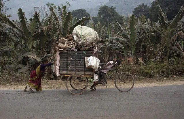 An impoverished Indian family transports recyclable material on a cart on the outskirts of Gauhati, India, Wednesday, February 1, 2017. India's finance minister pledged relief for middle class taxpayers and small and medium-sized companies on Wednesday, saying the government would spend billions of dollars to double farmers' incomes, upgrade ramshackle infrastructure and provide cheap housing. (Photo by Anupam Nath/AP Photo)