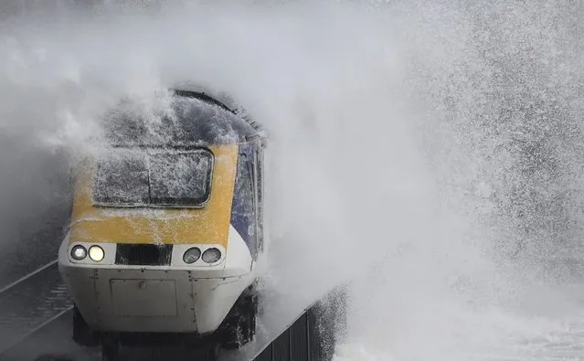 Waves hit a train during heavy seas and high winds in Dawlish in south west Britain, February 2, 2017. (Photo by Toby Melville/Reuters)