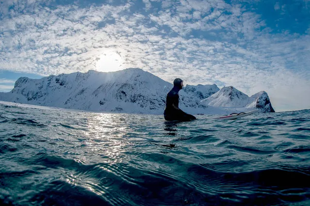 Surf instructor Tommy Olsen monitors his group of surf beginners during their 1st course at snowy beach of Unstad, in Lofoten Island, Arctic Circle, on March 09, 2016. Surfers from all over the world comes to Lofoten island to surf in extrem conditions. Ocean temperature is 6-7 °C, air temperature around 0°C in spite of a weather very unstable. (Photo by Olivier Morin/AFP Photo)
