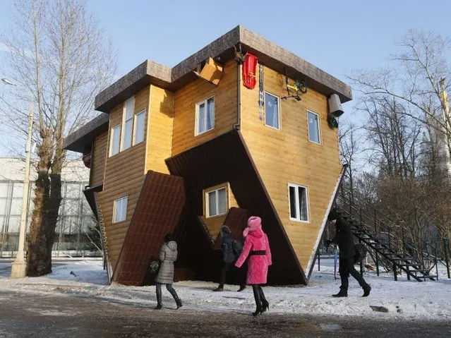 People look at an “Upside Down House” attraction displayed at the VVTs the All-Russia Exhibition Center in Moscow. (Photo by Yuri Kochetkov/EPA)