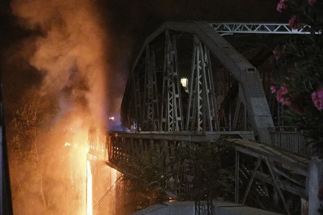 Flames engulf the Industry Bridge in Rome, early Sunday, October 3, 2021. A blaze, possibly sparked by a gas canister explosion, destroyed part of an historic bridge spanning the Tiber River in Rome before firefighters extinguished the flames early Sunday. (Photo by Mauro Scrobogna/LaPresse via AP Photo)