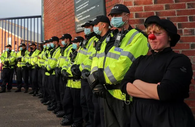An Extinction Rebellion activist wearing a clown's nose stands next to police officers during a protest outside BAE Systems, as the UN Climate Change Conference (COP26) takes place, in Glasgow, Scotland, Britain, November 4, 2021. (Photo by Russell Cheyne/Reuters)
