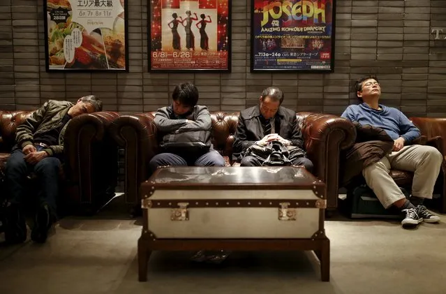 Men sleep in couches in a public seating area in a department store in Tokyo, Japan, March 17, 2016. (Photo by Thomas Peter/Reuters)
