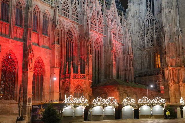 A man walks by a closed Christmas market, next to the St. Stephen's Cathedral in Vienna, Austria, Monday, November 22, 2021. Austria went into a nationwide lockdown early Monday to combat soaring coronavirus infections, a step being closely watched by other European governments struggling with national outbreaks that are straining health care systems.(Photo by Vadim Ghirda/AP Photo)