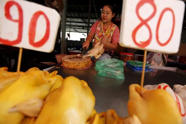 A vendor cuts chicken at her stall at a market in Bangkok, Thailand March 31, 2016. (Photo by Jorge Silva/Reuters)