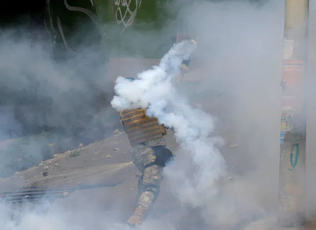 A riot policeman launches a tear gas canister towards coca growers from Yungas during the clashes in La Paz, Bolivia, February 21, 2017. (Photo by David Mercado/Reuters)