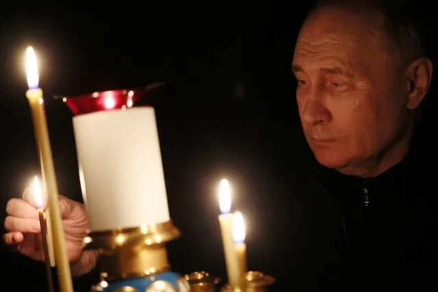 Russian President Vladimir Putin lights a candle in memory of the victims of the Crocus City Hall attack, on the day of national mourning in a church at the Novo-Ogaryovo state residence outside Moscow, on March 24, 2024. (Photo by Mikhail Metzel/Sputnik)