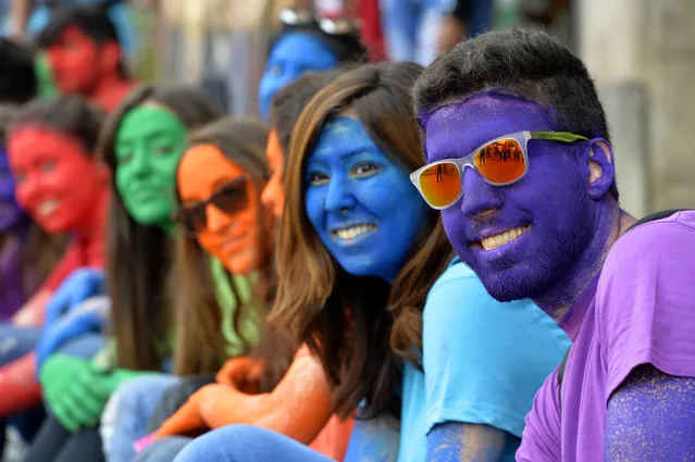 Lebanese people put powdered color on their faces as they pose for photographs during a Car Free Day at Monot street in Beirut, Lebanon, April 10, 2016. A Car Free Day is part of “Achrafieh 2020” initiative to create a better, less polluted, and greener environment. (Photo by Wael Hamzeh/EPA)