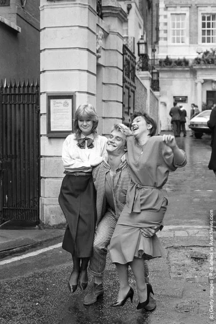 Swedish-born actor Dolph Lundgren shows off his muscles by sweeping two women off their feet at the same time, 1986