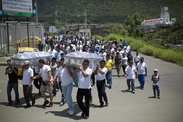 Relatives and villagers carry the coffins of Kexly Valentino and her brother Alex Valentino who died along their mother Gabriela in the earthquake, in Montecristi, Ecuador, Tuesday, April 19, 2016. (Photo by Rodrigo Abd/AP Photo)