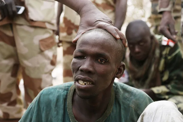 A man, whom the Chadian military say they have taken prisoner for belonging to insurgent group Boko Haram, is seen in Gambaru February 26, 2015. The Chadian military nicknamed the man “the Butcher”.  He was accused of killing five people the way Boko Haram does, cutting their throat with a knife. (Photo by Emmanuel Braun/Reuters)