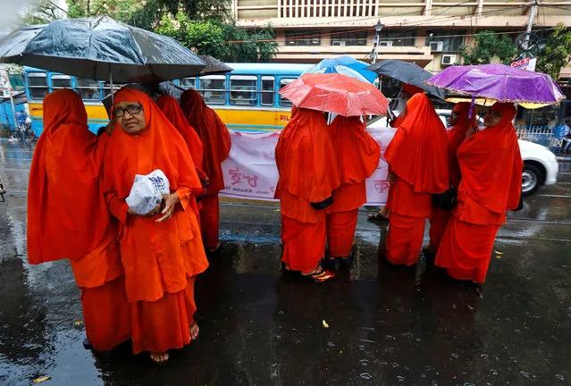 Hindu nuns hold their umbrellas as they wait to participate in a rally marking the International Women's Day in Kolkata, India, March 8, 2017. (Photo by Rupak De Chowdhuri/Reuters)