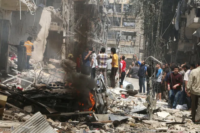 People inspect the damage at a site hit by airstrikes, in the rebel-held area of Aleppo's Bustan al-Qasr, Syria April 28, 2016. (Photo by Abdalrhman Ismail/Reuters)