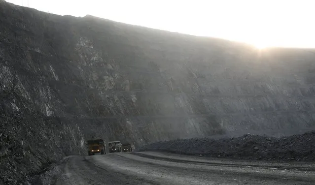 Dump trucks loaded with gold-bearing soil drive at the bottom of the 550-metre-deep Vostochny opencast of the Olimpiada gold operation, owned by Polyus Gold International company, in Krasnoyarsk region, Eastern Siberia, Russia, June 30, 2015. (Photo by Ilya Naymushin/Reuters)