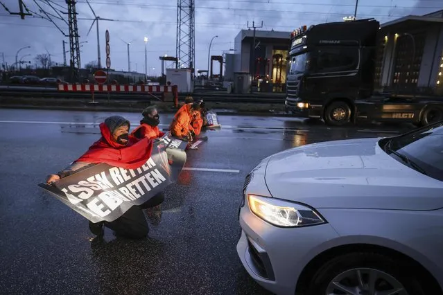 Climate activists of the self named group ”Uprising of the last generation” block an intersection at the highway A7 in Hamburg, Germany, Monday, February 21, 2022. The banner reads: “Save Food, Save Life”. (Photo by Christian Charisius/dpa via AP Photo)