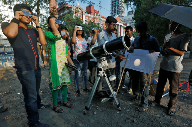 People look at planet Mercury transiting across the sun with solar filters at a public viewing in Kolkata, India May 9, 2016. (Photo by Rupak De Chowdhuri/Reuters)