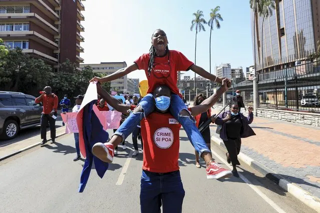A man carries a woman on his sholders as they join a rally a day after a video of a woman allegedly being sеxually harassed by boda boda (motorcycle taxi) riders went viral, during the International Women's Day celebrations, in Nairobi, Kenya, 08 March 2022. Police said a woman was on 04 March cornered and molested by bodabodas after she knocked a pedestrian, 16 riders are questioned by the police. International Women's Day is globally observed on 08 March to highlight the struggles of women around the globe. It was recognized by the United Nations General Assembly as the day for women's rights and world peace in 1977. The theme for this year's International Women's Day is “Gender equality today for a sustainable tomorrow”. (Photo by Daniel Irungu/EPA/EFE)