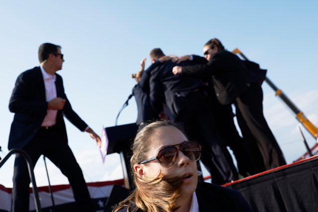 Republican presidential candidate former President Donald Trump is rushed offstage by U.S. Secret Service agents after being grazed by a bullet during a rally on July 13, 2024 in Butler, Pennsylvania. Butler County district attorney Richard Goldinger said the shooter is dead after injuring former U.S. President Donald Trump, killing one audience member and injuring another in the shooting. (Photo by Anna Moneymaker/Getty Images)