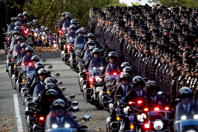 A procession of police motorcycles passes officers lining the street at the funeral service for shot New York City Police Department (NYPD) officer Brian Mulkeen at the Sacred Heart Church in Monroe, New York, U.S., October 4, 2019. (Photo by Mike Segar/Reuters)