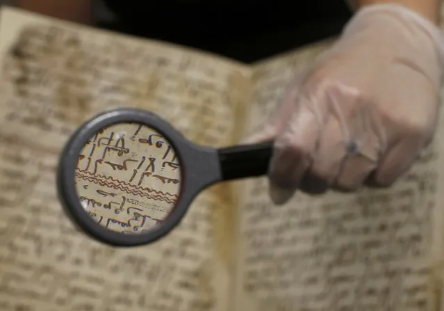 A detail of a fragment of a Koran manuscript is seen through a magnifying glass in the library at the University of Birmingham in Britain July 22, 2015. (Photo by Peter Nicholls/Reuters)