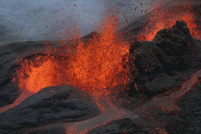 A picture taken on May 26, 2016 on the French island of La Reunion shows lava during the eruption of the Piton de la Fournaise volcano, in an unhabitated area.  
The last Piton de la Fournaise's eruption occured on October 30, 2015. (Photo by Richard Bouhet/AFP Photo)