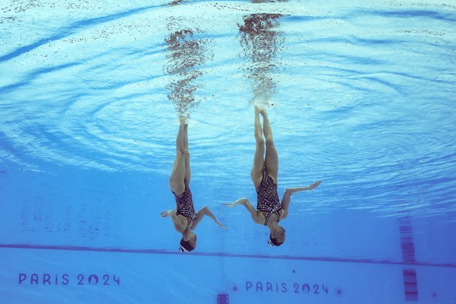 An underwater view shows France's Anastasia Bayandina and France's Romane Lunel competing in the duet technical routine of the artistic swimming event during the Paris 2024 Olympic Games at the Aquatics Centre in Saint-Denis, north of Paris, on August 9, 2024. (Photo by Marko Djurica/Reuters)