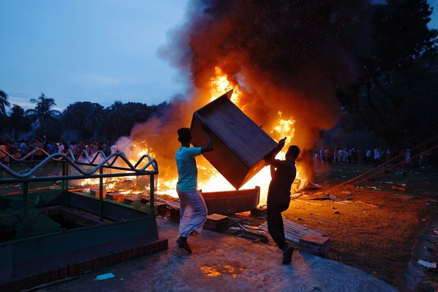 People throw wooden furniture into the fire that was set on a vehicle inside the Ganabhaban, the Prime Minister's residence, after the resignation of the Sheikh Hasina in Dhaka, Bangladesh, on August 5, 2024. (Photo by Mohammad Ponir Hossain/Reuters)