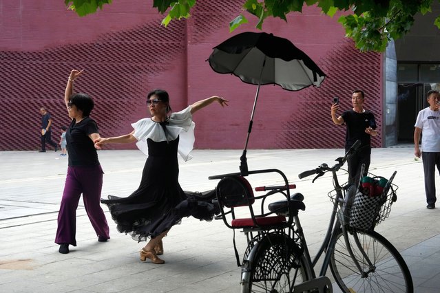 Chinese women take part in plaza dancing, a popular pastime for retirees in Beijing, Tuesday, August 6, 2024. (Photo by Ng Han Guan/AP Photo)