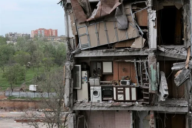 A part of an apartment is seen at the side of damaged during a heavy fighting buildings in Mariupol, in territory under the government of the Donetsk People's Republic, eastern Ukraine, Thursday, May 13, 2022. (Photo by AP Photo/Stringer)