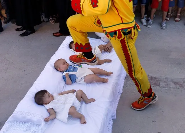 A man dressed up as the devil jumps over babies lying on a mattress in the street during “El Colacho”, the “baby jumping festival” in the village of Castrillo de Murcia, near Burgos on June 18, 2017. (Photo by Cesar Manso/AFP Photo)
