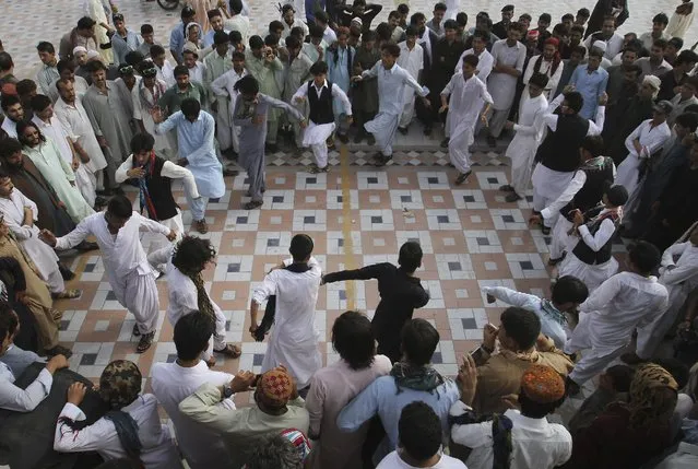Pakistani Pashtun people perform their traditional dance at Clinfton beach to celebrate Eid al-Fitr holidays in Karachi, Pakistan, Sunday, July 19, 2015. (Photo by Farid Khan/AP Photo)