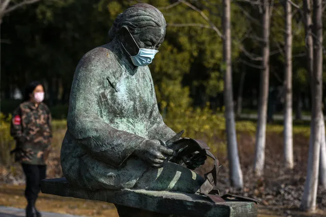 This photo taken on February 2, 2020 shows sculptures wearing protective facemasks at a park in Huaian in China's eastern Jiangsu province, amid a virus outbreak that originated from Hubei's provincial capital city of Wuhan. China's death toll from the coronavirus epidemic soared past 360 on February 3, with deepening global concern about the outbreak and governments closing their borders to people from China. (Photo by AFP Photo/China Stringer Network)
