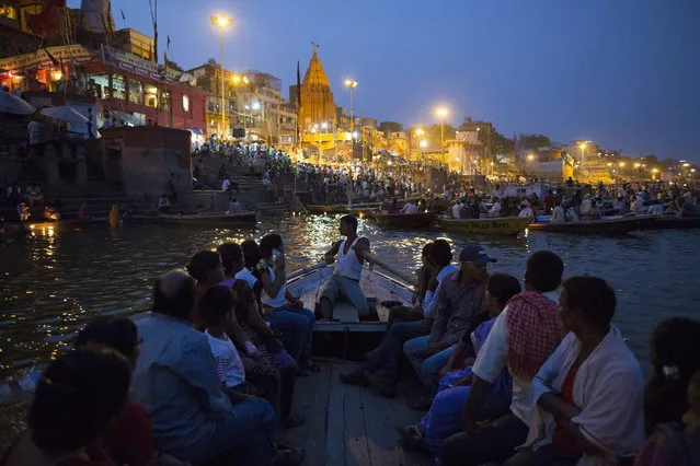 Hindu devotees travel past holy ghats on the banks of the river Ganges in Varanasi, in the northern Indian state of Uttar Pradesh, June 16, 2014. (Photo by Danish Siddiqui/Reuters)