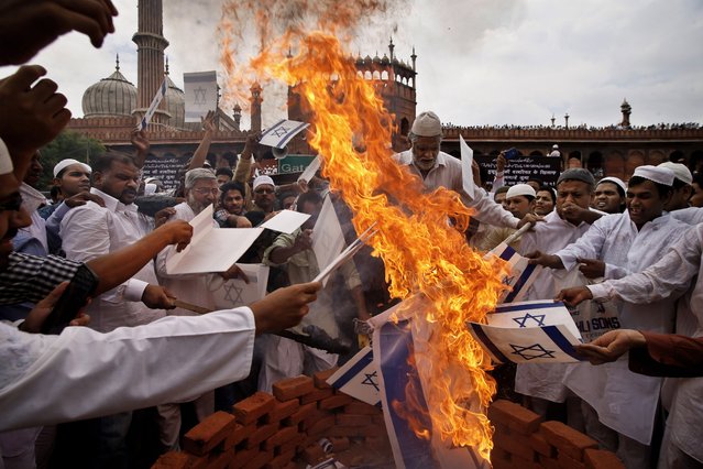 Indian Muslims burn a flag of Israel as they protest against Israel's attack on Gaza, after friday afternoon prayers at Jama Masjid in New Delhi, India, Friday, July 25, 2014. (Photo by Saurabh Das/AP Photo)