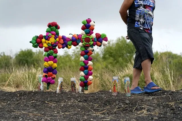A man pays his respects at the site where officials found dozens of people dead in a semitrailer containing suspected migrants, Tuesday, June 28, 2022, in San Antonio. (Photo by Eric Gay/AP Photo)